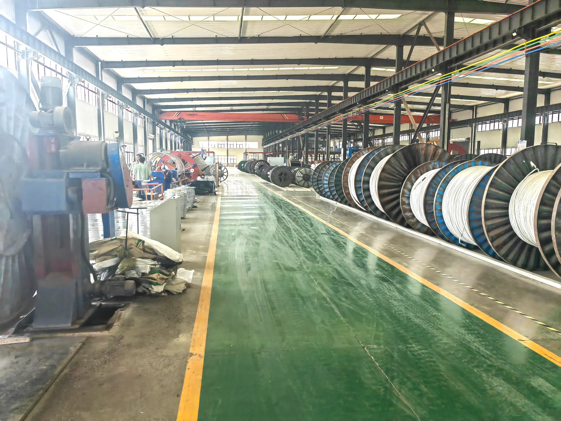 Factory quality control technician performing high-voltage withstand test on cable drum with test equipment